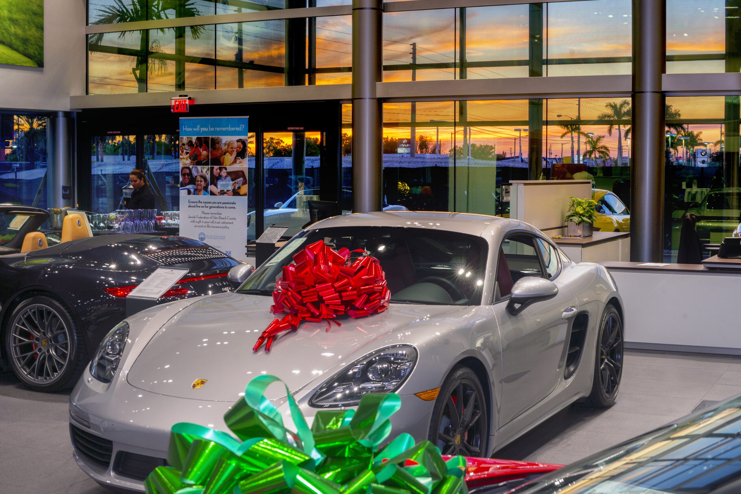 Luxury Porsche dealership event in Palm Beach, Florida, hosted by the Jewish Federation of Palm Beach County — featuring sleek sports cars under a sunset sky, photographed by David Scarola Photography.Porsche Palm Beach event photography, Jewish Federation Palm Beach County gala, luxury event photographer Florida, high-end automotive event photography, corporate event photographer Palm Beach, global luxury brand photographer, philanthropic event photography, David Scarola Photography, worldwide corporate events, high-profile Palm Beach event photography, exclusive gala photographer.