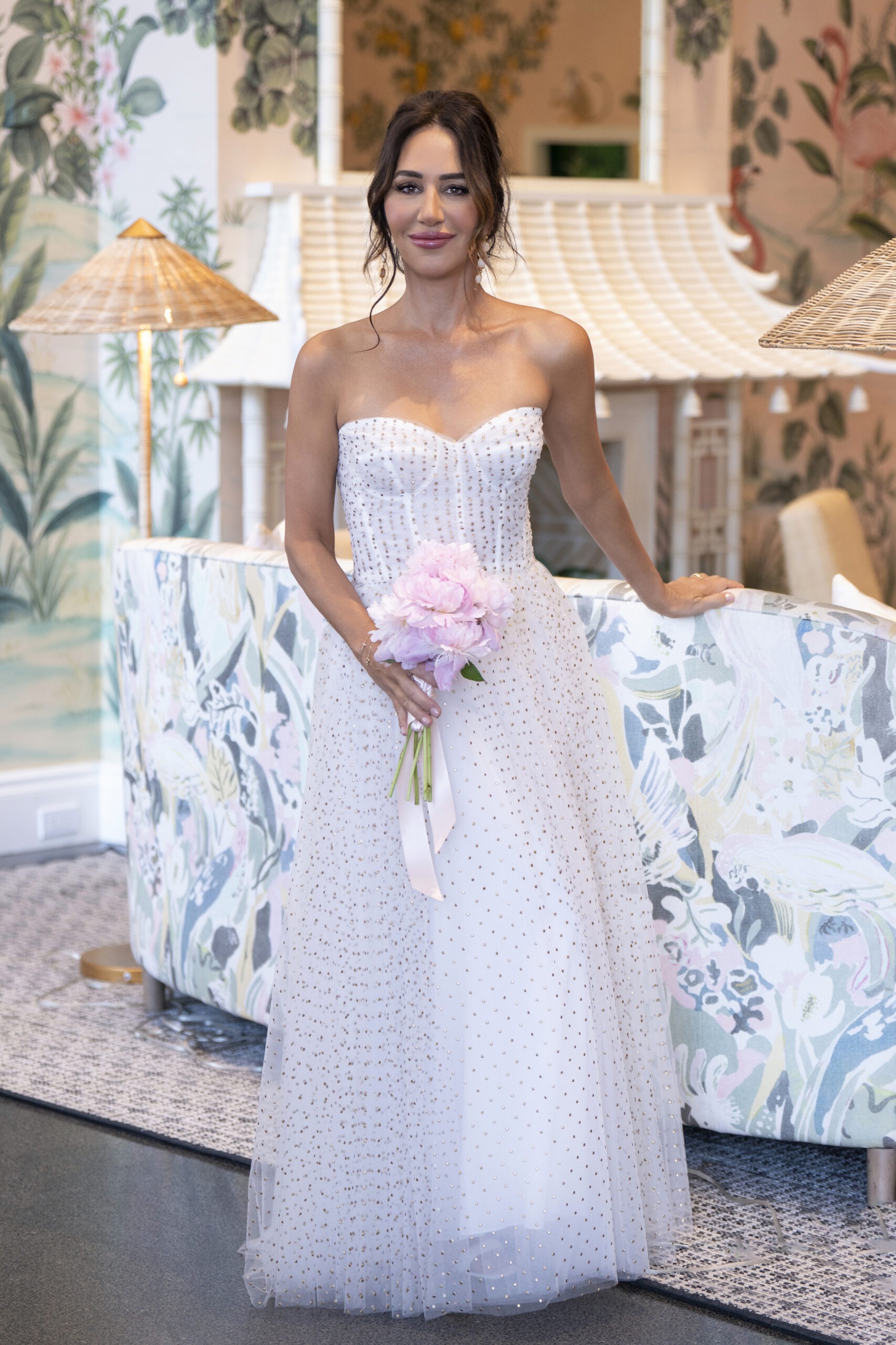Bride standing gracefully in the iconic lobby of The Colony Hotel, Palm Beach Island — surrounded by its signature pastel decor and tropical artistry. Her jeweled gown and soft pink bouquet radiate effortless sophistication and coastal romance. Captured by award-winning Palm Beach wedding photographer David Scarola, renowned for blending fine-art elegance, cinematic light, and timeless storytelling into editorial-level wedding photography that defines luxury on Florida’s Gold Coast.