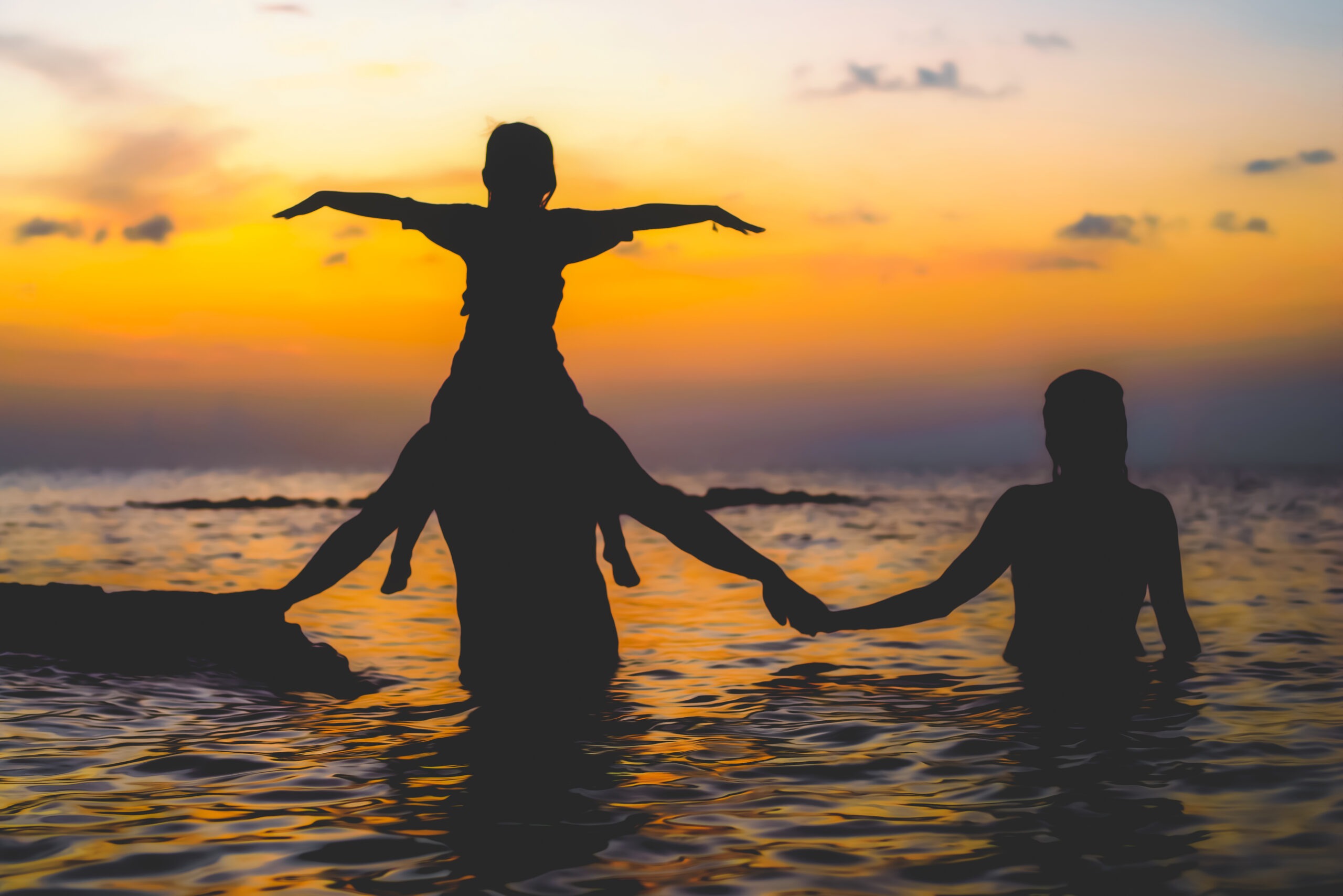 Marsh Harbour in the Abaco Islands makes for one heck of a world class backdrop for a family portrait session. The little girl riding on dad's shoulder. Dad and mom holding hands. The sun has just settled in beyond the horizon. There's so much delicious color bursting in the skies. This moment during a photo session with David Scarola says it all!