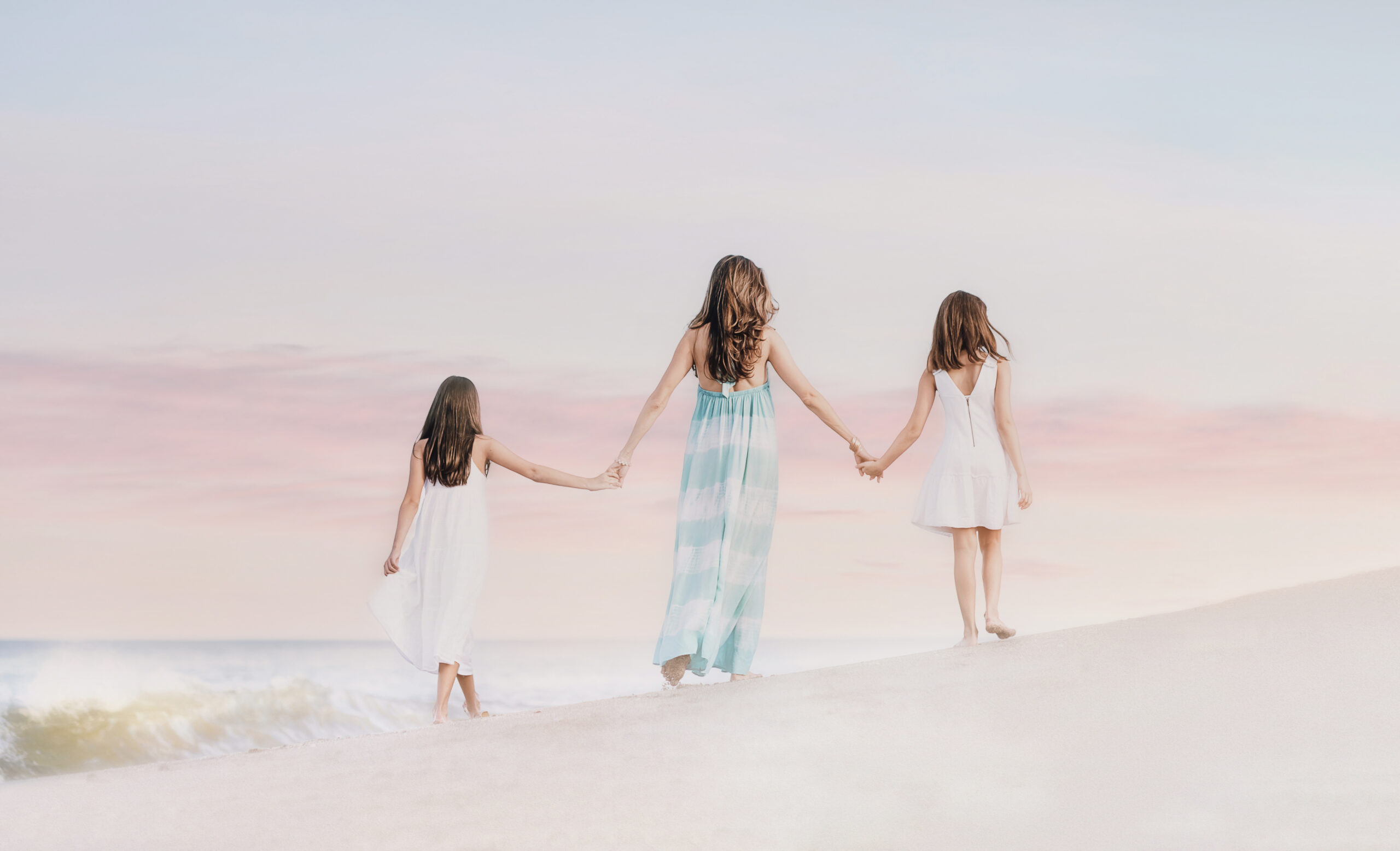 Soft and dreamlike pastel skies at sunset on the beach in Palm Beach makes for a picture perfect and a glorious and delightful setting for this mother and her daughters during their family portrait session with David Scarola Photography.