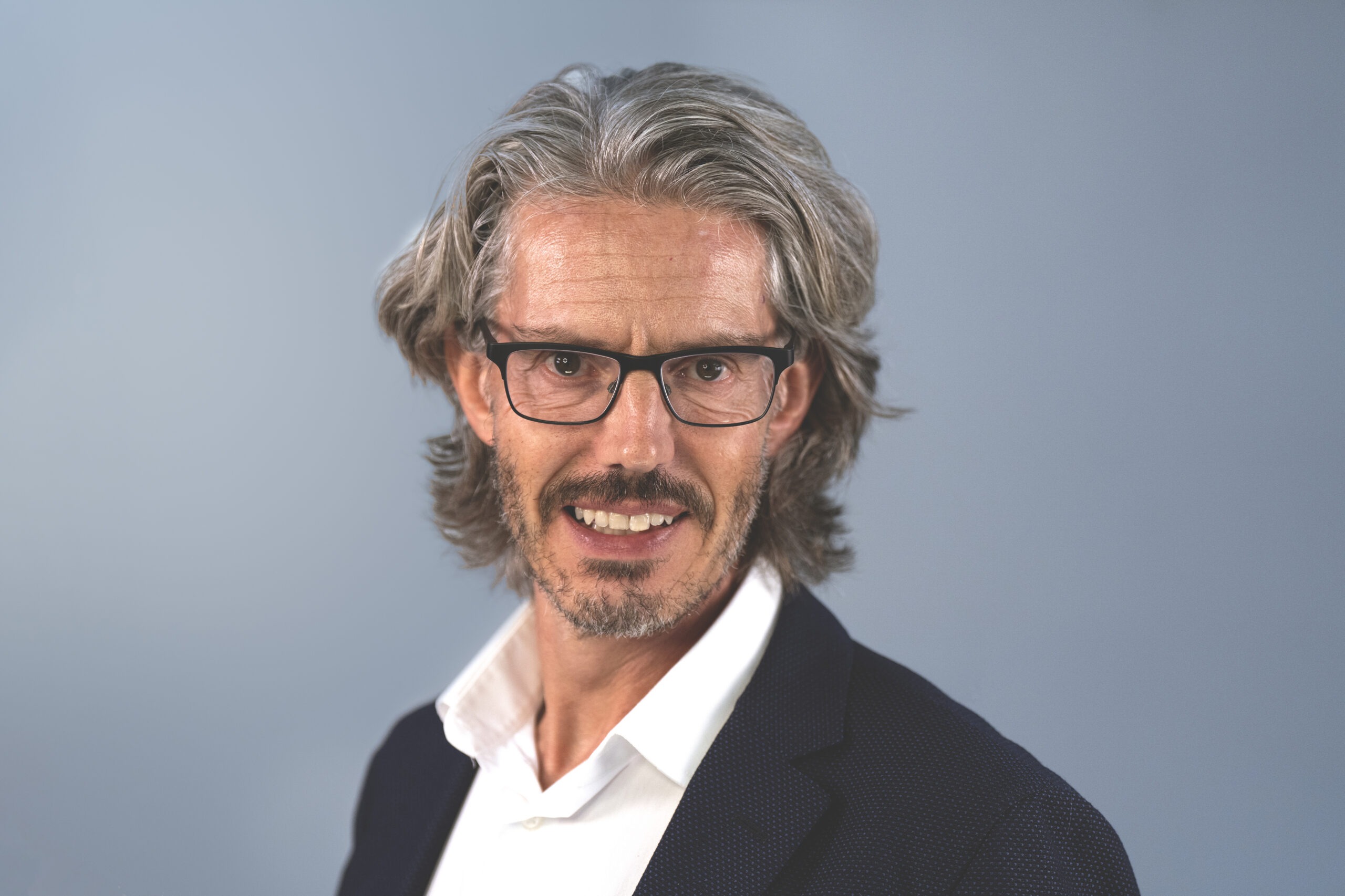 Professional headshot of a South Florida realtor in a navy blazer and white shirt, smiling confidently against a clean studio background. Captured by David Scarola Photography, specializing in real estate and business headshots in Palm Beach and Jupiter, Florida.realtor headshot South Florida, Palm Beach real estate photography, Jupiter FL professional headshots, business portrait photography Florida, luxury realtor headshots, David Scarola Photography, branding portraits for realtors, professional LinkedIn headshots Palm Beach, commercial portrait photographer Florida, best headshot photographer in South Florida.