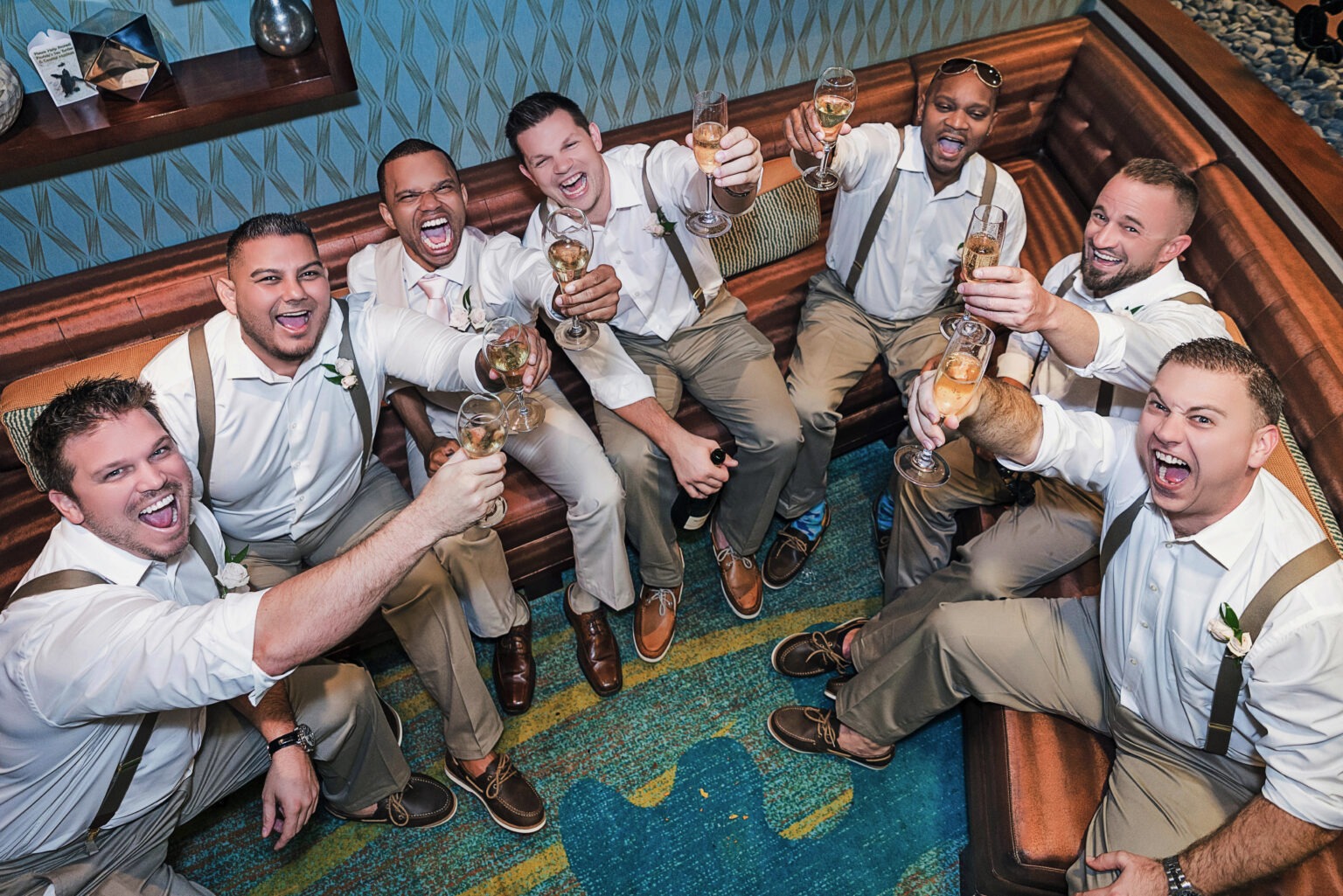 Groom and his groomsmen toasting and laughing together in celebration at The Breakers in Palm Beach, Florida — captured with energy, joy, and authenticity by David Scarola, Florida’s best wedding photographer and master of dynamic, fine-art portraiture that brings luxury weddings to life.
