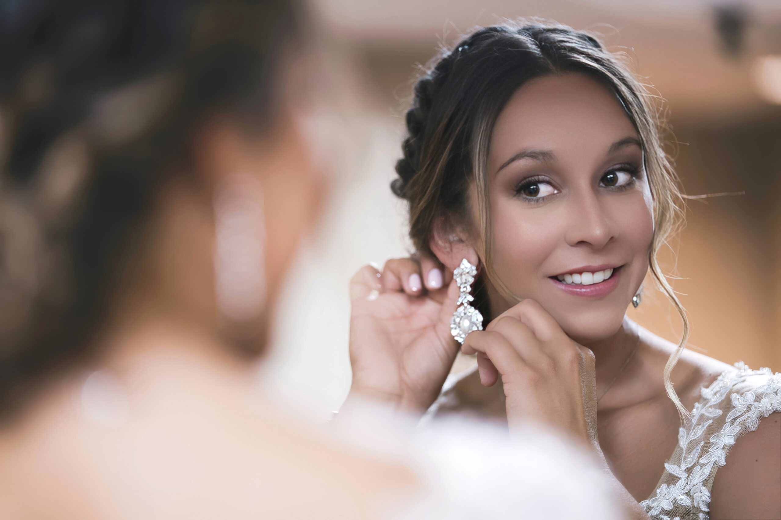 Palm Beach bride getting ready on her wedding day, smiling as she puts on her crystal earrings before walking down the aisle. Captured by fine-art wedding photographer David Scarola, this elegant preparation portrait highlights the luminous beauty, emotion, and anticipation of a Palm Beach Island wedding.