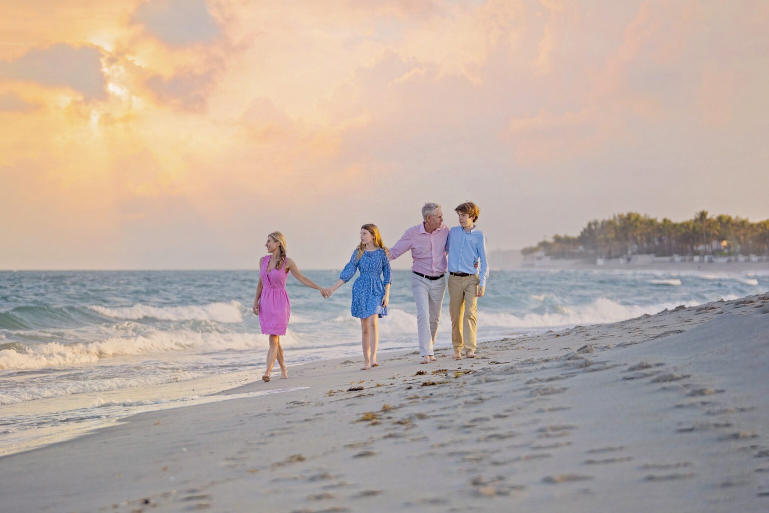 Family walking barefoot along the shoreline during a golden Palm Beach Island sunset. Captured by David Scarola Photography, specializing in luxury beach family portraits, fine art photography, and Palm Beach lifestyle imagery.Palm Beach Island family photographer, Palm Beach sunset photography, beach portraits Florida, luxury family photographer Palm Beach, Jupiter Island family photography, professional beach portraits, fine art family photography South Florida, family photography at sunset, best Palm Beach photographer, David Scarola Photography.
