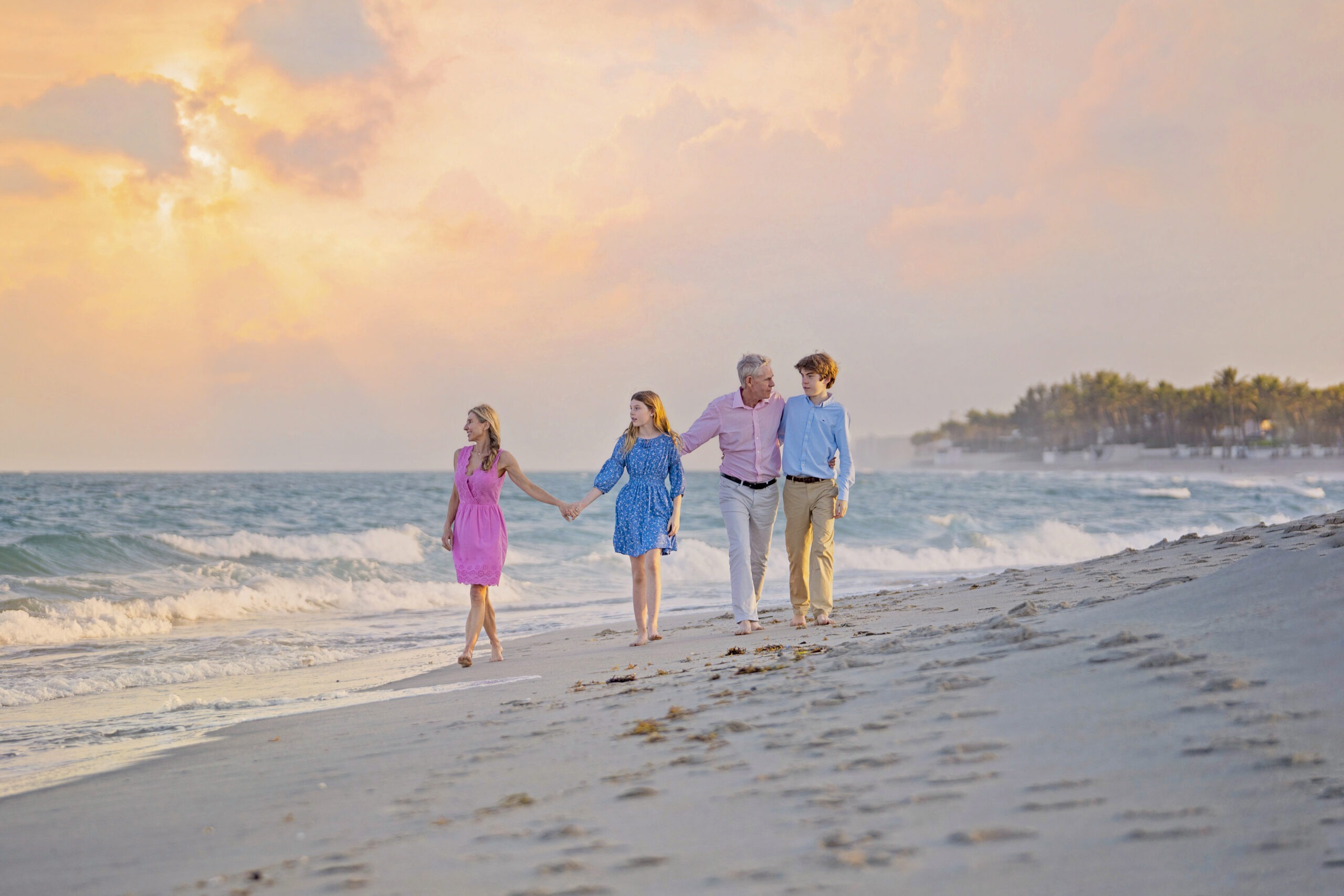 Family walking barefoot along the shoreline during a golden Palm Beach Island sunset. Captured by David Scarola Photography, specializing in luxury beach family portraits, fine art photography, and Palm Beach lifestyle imagery.Palm Beach Island family photographer, Palm Beach sunset photography, beach portraits Florida, luxury family photographer Palm Beach, Jupiter Island family photography, professional beach portraits, fine art family photography South Florida, family photography at sunset, best Palm Beach photographer, David Scarola Photography.
