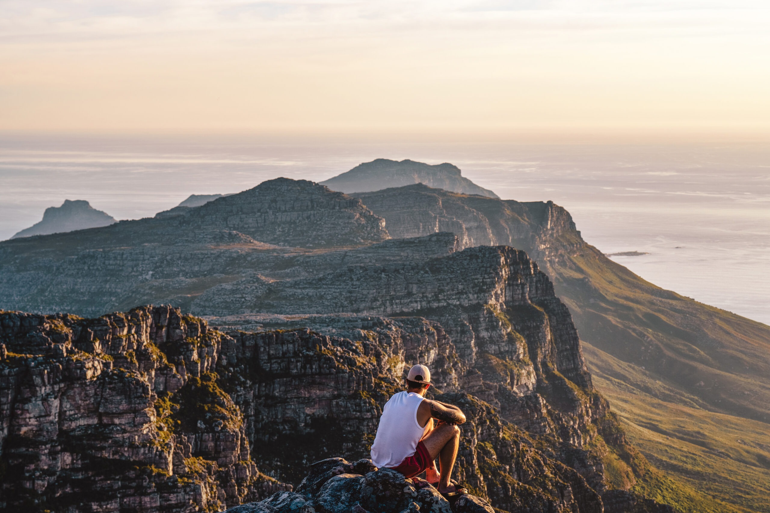 An International Academy of Trial Lawyers fellow pauses at sunset atop Table Mountain in Cape Town, South Africa, gazing across the Twelve Apostles mountain range — captured by David Scarola during a global corporate adventure.Table Mountain Cape Town photography, International Academy of Trial Lawyers adventure, global corporate event photographer, Cape Town sunset photography, David Scarola Photography, commercial event coverage South Africa, corporate retreat photography, executive travel photographer, international conference photographer, fine art adventure photography, luxury travel documentation, destination event photographer, Cape Peninsula landscape photography.