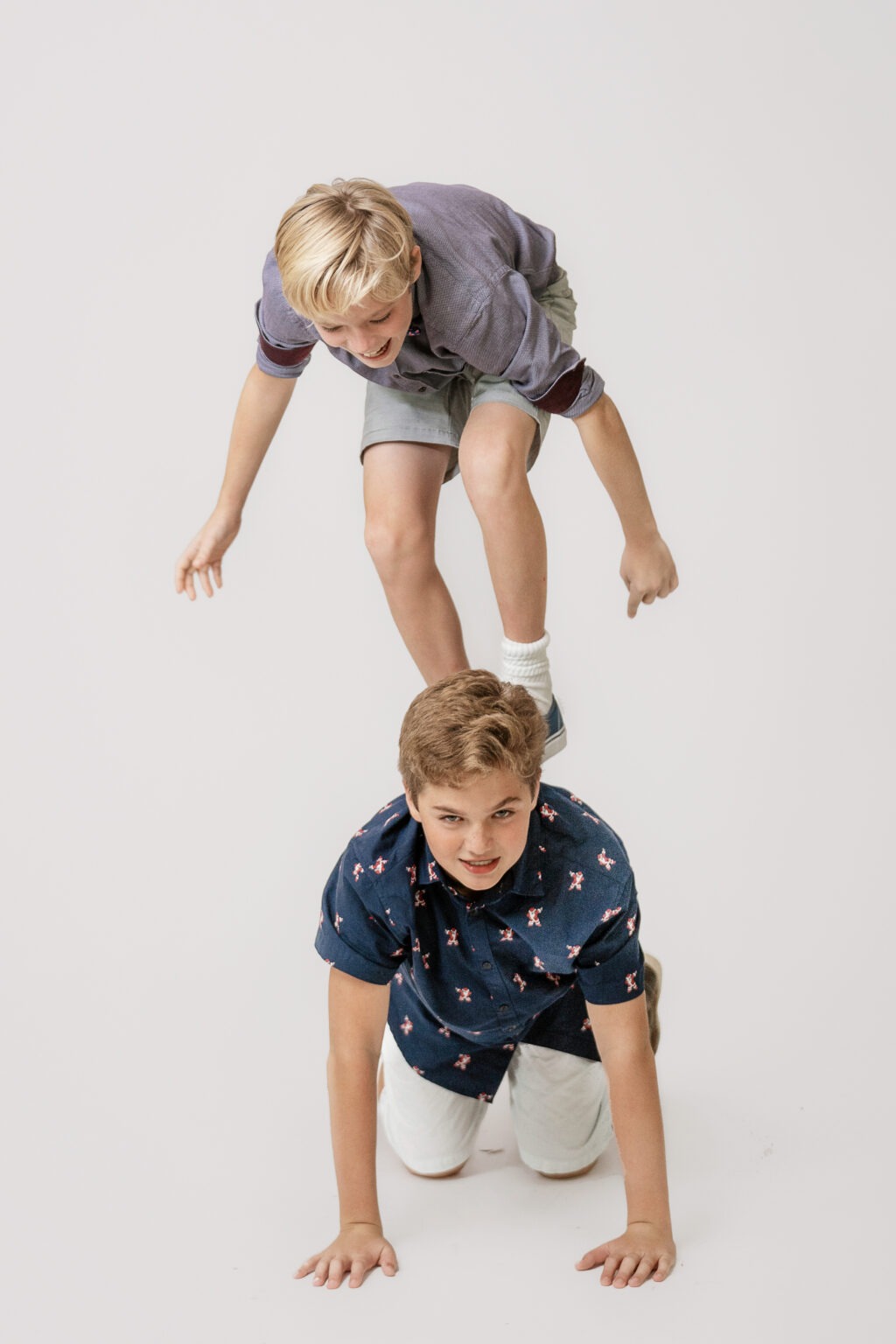 Two young brothers playing joyfully in Daivd Scarola's brightly lit fine art and portrait studio and gallery in Palm Beach, Florida.