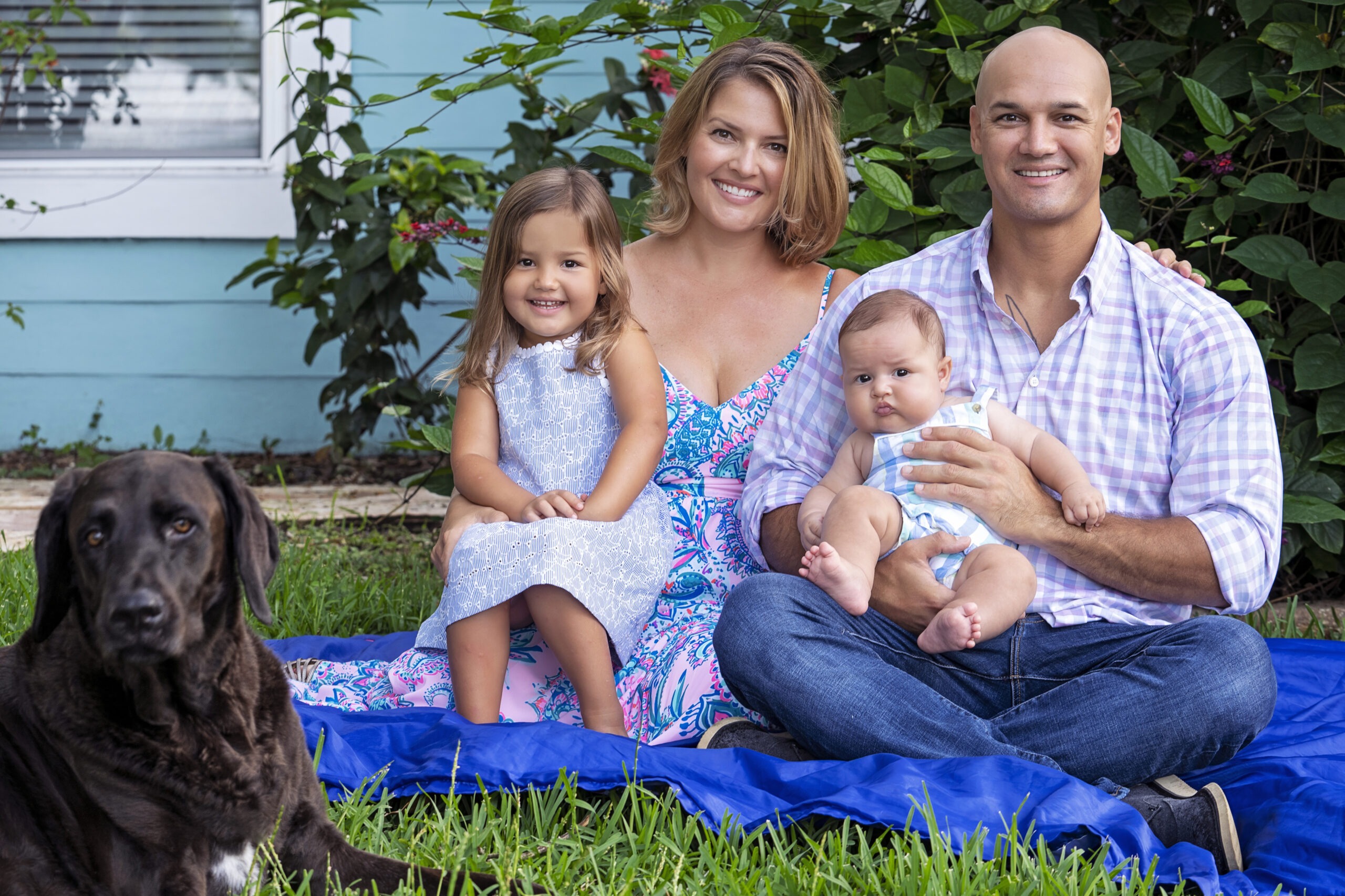 Family portrait session in Juno Beach Isles, Florida — a mother, father, two young children, and their loyal dog captured on the grass of their backyard by master portrait artist David Scarola.family photography Juno Beach FL, backyard family portraits, Palm Beach County family photographer, Florida portrait artist, candid family photography, David Scarola Photography, fine art portraits, best family photographer USA