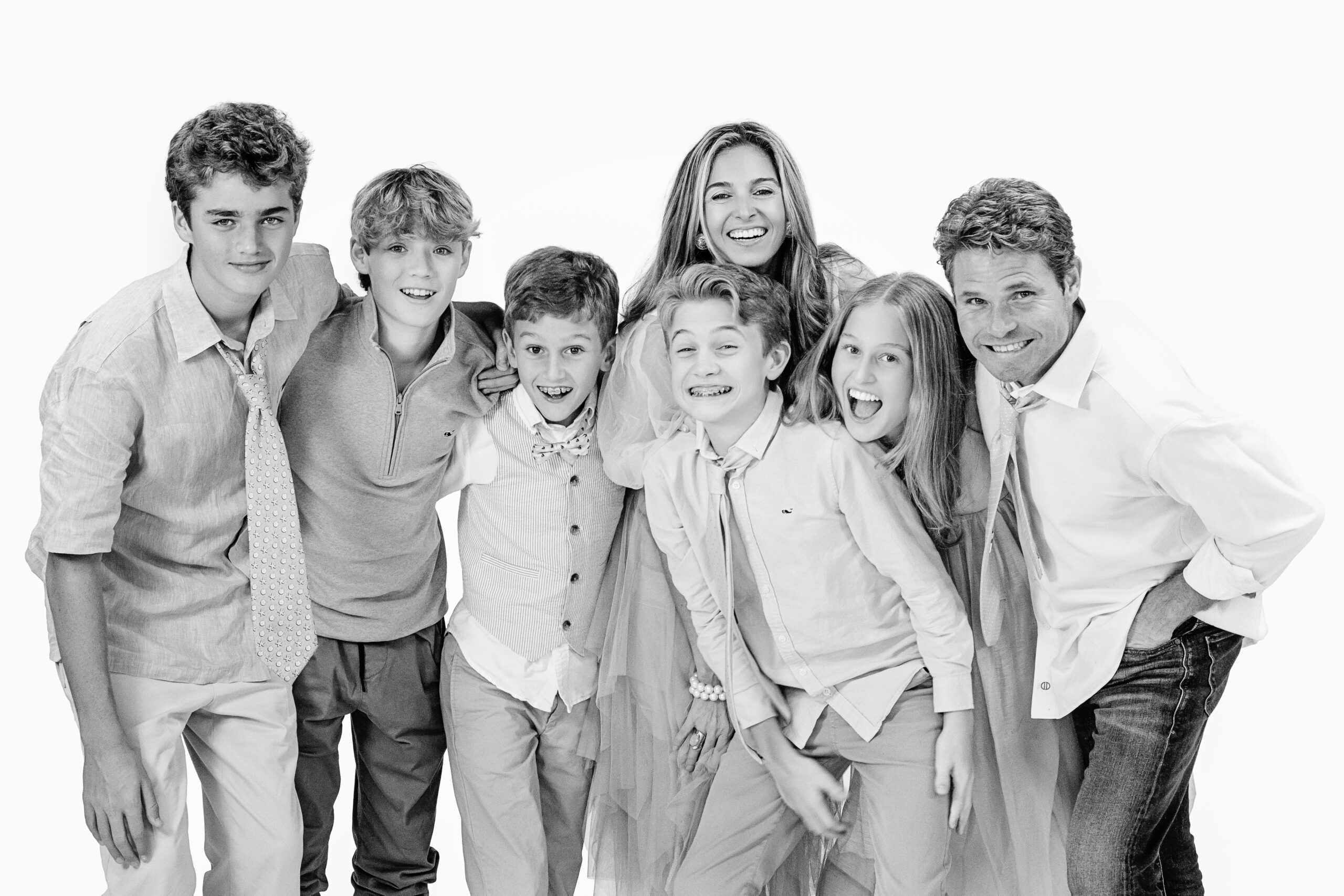 A family of 7 posing and playing in David's Palm Beach Studio and Gallery. A master of his craft and putting everyone in the family at ease, David captures those wonderful moments, because he is a true professional who puts everyone at ease. Love is in the air in David Scarola's happy studio.