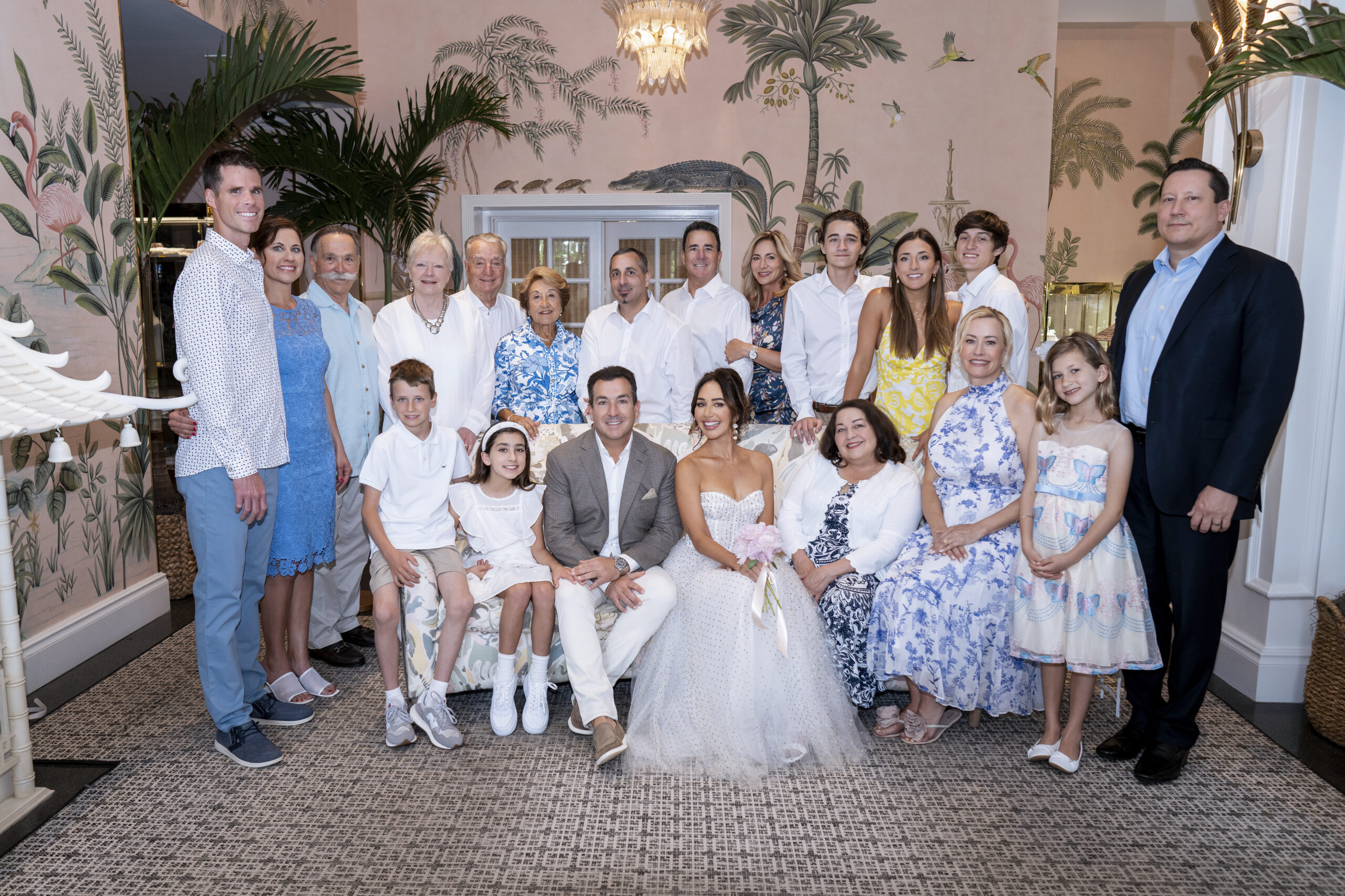 A large family gathered for a wedding celebration at The Colony Hotel on Palm Beach Island, featuring Chris and Melissa seated in the center, surrounded by their smiling loved ones in elegant attire beneath tropical décor.A heartwarming family portrait of three brothers captured at the Jupiter Lighthouse Center. Each child’s joy and bond is illuminated through the lens of master portrait artist David Scarola — Florida’s premier family photographer. Known for blending natural light, authentic emotion, and refined artistry, David’s portraits are timeless keepsakes of love and connection.