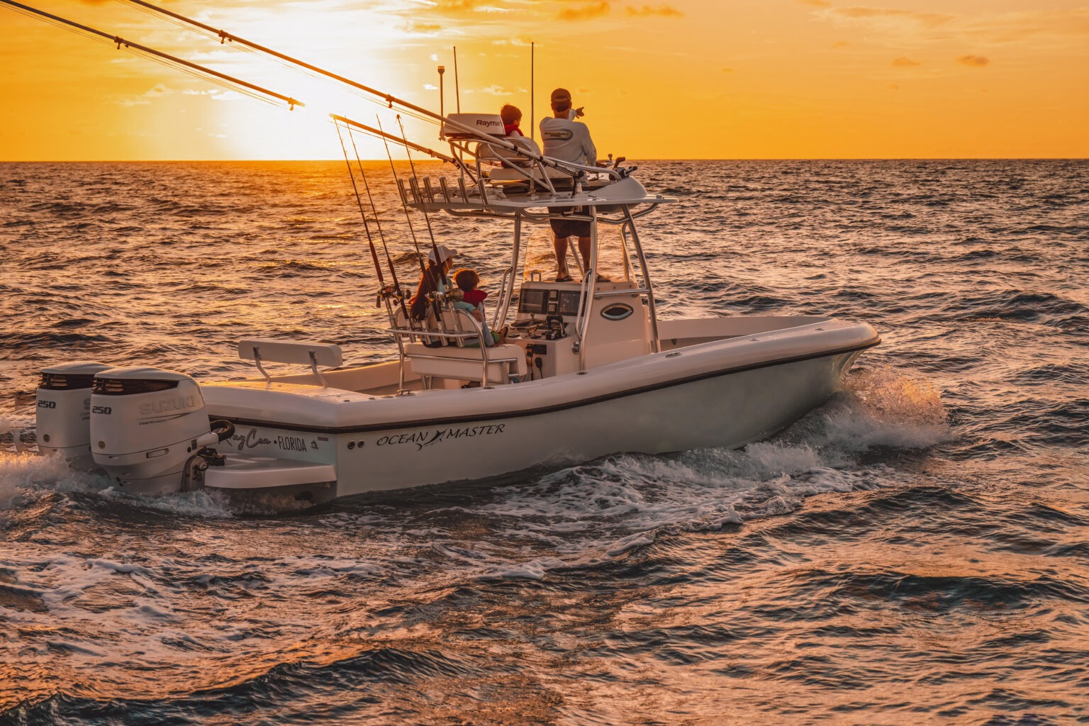 Family portrait at sunrise aboard a fishing boat on the Atlantic Ocean near Jupiter Island, Florida. The family enjoys the golden morning light over calm waters, captured in warm tones by David Scarola Photography, known for his masterful lifestyle and oceanfront family portraits.family photographer Jupiter FL, ocean sunrise portraits, Jupiter Island family photography, Palm Beach lifestyle photographer, boating family portraits Florida, Ocean Master family shoot, sunrise photography Jupiter Island, fine art family photographer South Florida, David Scarola Photography, family photos on the water Florida.