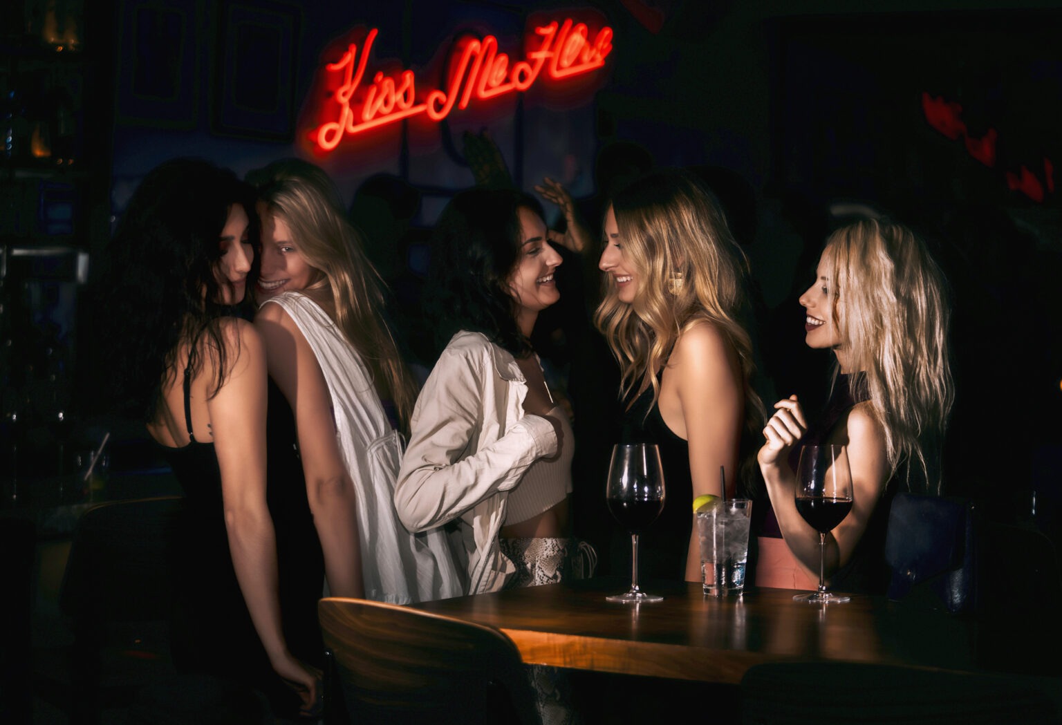 A lively ladies’ night scene at Cucina Palm Beach, featuring a group of women in elegant evening attire sharing laughter beneath a glowing red neon “Kiss Me Here” sign. Captured in warm, cinematic light, the image embodies luxury nightlife, friendship, and the sophisticated energy of Palm Beach Island.Palm Beach photographer, Cucina Palm Beach, Palm Beach nightlife photography, luxury lifestyle photographer, event photographer Palm Beach, ladies night photography, restaurant marketing photos, promotional campaign photography, global event photographer, David Scarola Photography, fine art commercial photography, hospitality marketing visuals, editorial event photography.